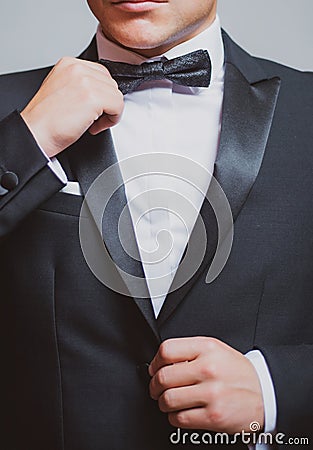 Man in black suit wearing bow tie. Male fashion. Formal suit classic style outfit. Elegant and stylish hipster. Stock Photo
