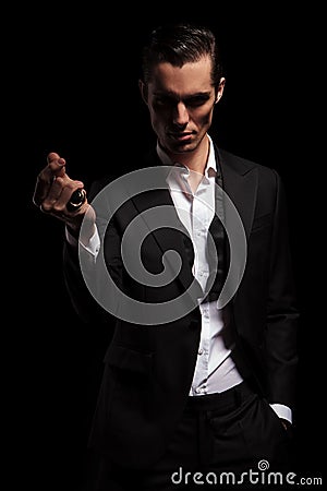 Man in black tuxedo with hand in pocket snapping fingers Stock Photo