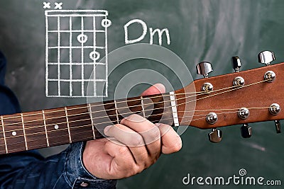 Man playing guitar chords displayed on a blackboard, Chord Dm Stock Photo