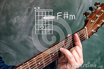 Man playing guitar chords displayed on a blackboard, Chord F sharp minor Stock Photo