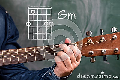 Man playing guitar chords displayed on a blackboard, Chord Gm Stock Photo