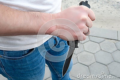 A man with a black pocket folding knife in his hand Stock Photo
