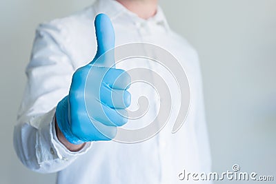 Man in blue medical glove showing approval thumbs up sign on white background with copy space for text Stock Photo