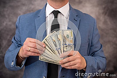 Man in blue suit count stack of dollar bills Stock Photo