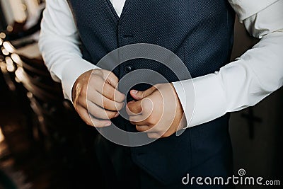 A man in a blue suit zips up his jacket, close-up. Businessman changing clothes.Tonal correction. FASHION, STYLE Stock Photo