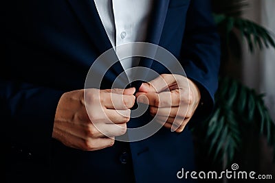 A man in a blue suit zips up his jacket, close-up. Businessman changing clothes.Tonal correction. FASHION, STYLE Stock Photo