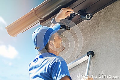 Man install outdoor surveillance ip camera for home security Stock Photo