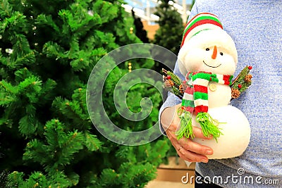 A man bought large funny snowman in the store, a gift for a child for his birthday, Christmas, new year. Christmas shopping in Stock Photo