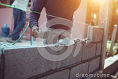 Man bricklayer building a brick wall or wall construction Stock Photo