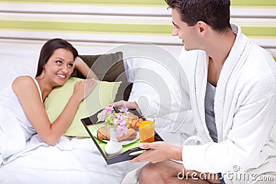 Man bringing breakfast in bed Stock Photo