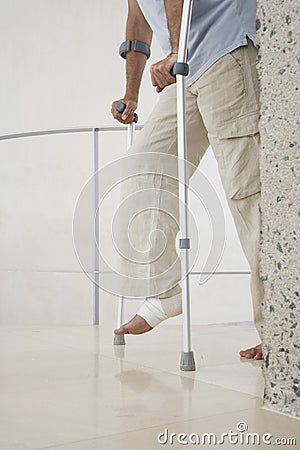 Man With Broken Leg Walking With Crutches Stock Photo