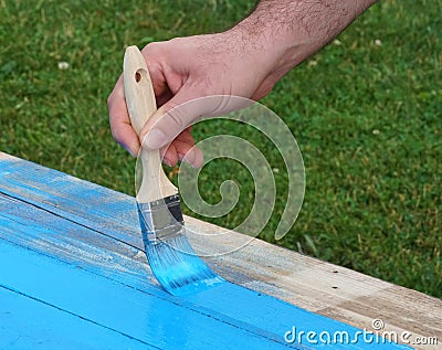 Man with brush paints wooden boards Stock Photo