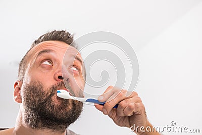 Man brushing his teeth in bathroom Stock Photo