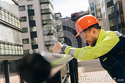 Man builder in helmet closeup, upset in shock, holding his head. Fire fighting concept. house burned down Stock Photo