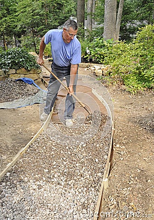 Man building gravel path Stock Photo