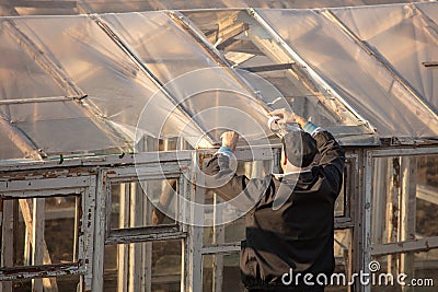 A man builds a greenhouse in the country Editorial Stock Photo