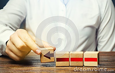 Man builds an red arrow from blocks. Business development, growth process concept. Progress and movement forward. Career promotion Stock Photo