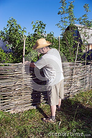 The man builds a wattle fence Stock Photo