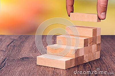 Man builds a wooden ladder. Concept: stable development Stock Photo