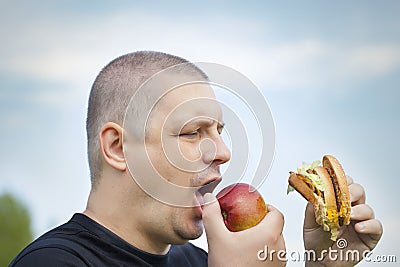 Man with burger and apple Stock Photo