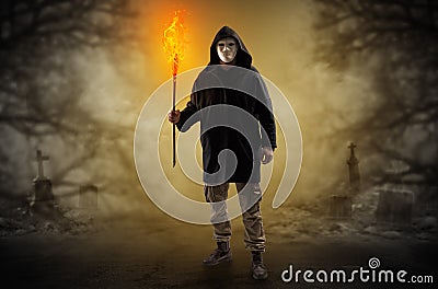 Man coming out from a thicket with burning flambeau Stock Photo