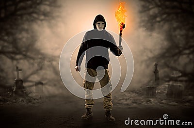 Man coming out from a thicket with burning flambeau Stock Photo