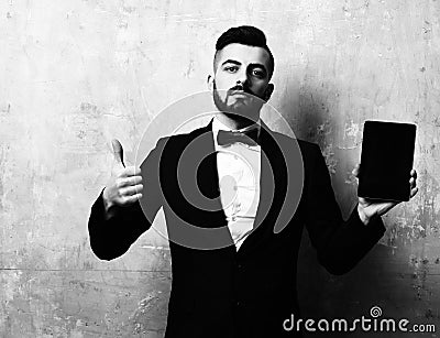 Man of business with beard holds tablet and thumb up Stock Photo