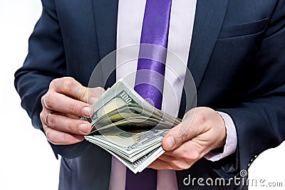 Man in business suit counts one hundred dollar denominations Stock Photo