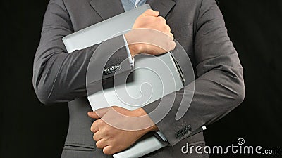 Man in business suit holding laptop computer tight, personal data security Stock Photo
