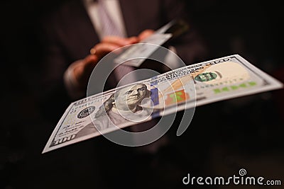 Man in business suit litter money, dollars closeup Stock Photo