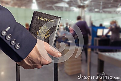 Man businessman in a blue suit with suitcase holding american passport in the airport opposite customs control or security Stock Photo