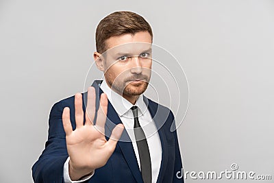 Man businessman gestures to stop. Business guy shows open palm meaning stop enough urging to avast. Stock Photo