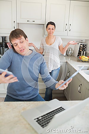 Man busy with technology while his wife wondering why Stock Photo