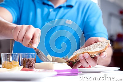 Man buttering a slice of wholewheat bread Stock Photo