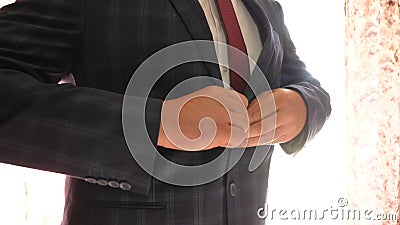 Man button up his buttons on his jacket, close-up. businessman puts on a blue jacket in a cage. office worker gets Stock Photo