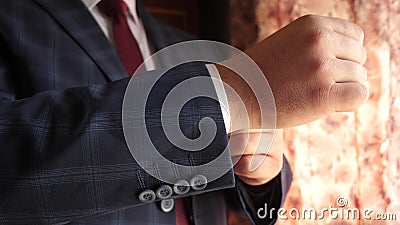 Businessman in red tie dark blue check suit straightens sleeve of white shirt. dark blue check suit. office worker gets Stock Photo