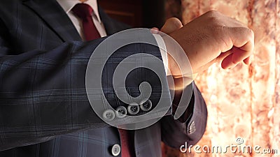 Businessman in red tie dark blue check suit straightens sleeve of white shirt. dark blue check suit. office worker gets Stock Photo