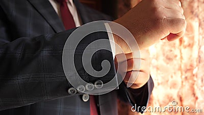 Businessman in red tie dark blue check suit straightens sleeve of white shirt. dark blue check suit. office worker gets Stock Photo