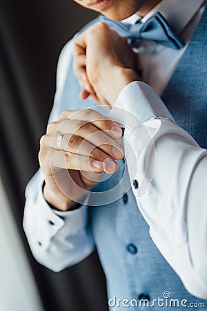 Man buttons cuff link on cuffs sleeves luxury white shirt. Stock Photo