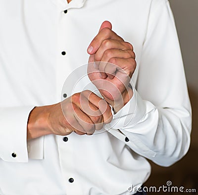 Man buttons cuff-link on French cuffs sleeves luxury white shirt Stock Photo