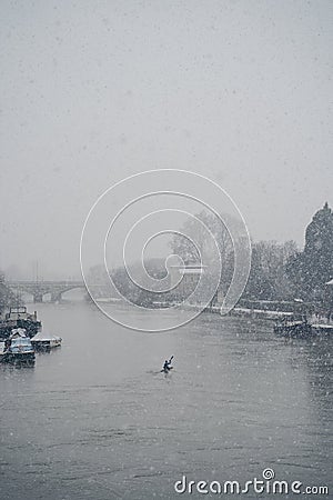 Man in canoe on a snowy Sunday morning on the river Thames Editorial Stock Photo