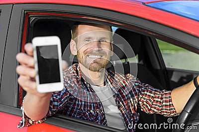 Man in car driving showing smart phone Stock Photo