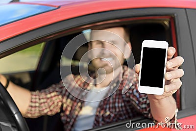 Man in car driving showing smart phone Stock Photo