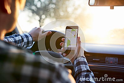 Man in the car holding mobile phone with map gps navigation Stock Photo