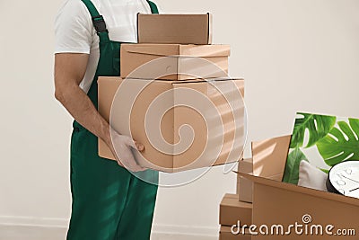 Man with cardboard boxes in room. Moving service Stock Photo