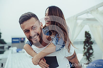 Man carries girlfriend on his back Stock Photo