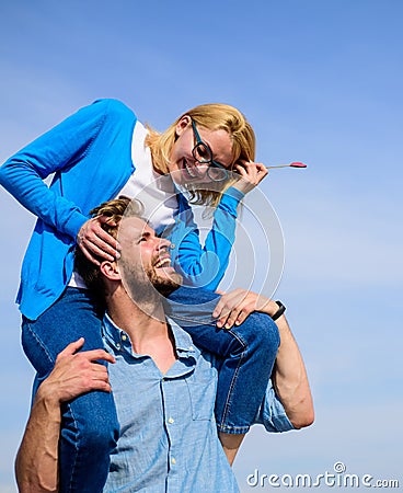 Man carries girlfriend on shoulders, sky background. Woman enjoy perfect romantic date. Couple happy date having fun Stock Photo