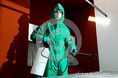 Man carrying bleach tank while sanitizing the kitchen stock photo Stock Photo