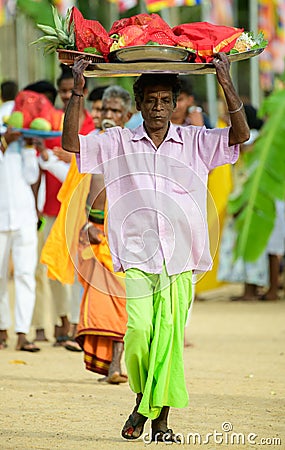 Man carrying fruits offering tray over the head during the festive season at Ruhunu Maha Editorial Stock Photo