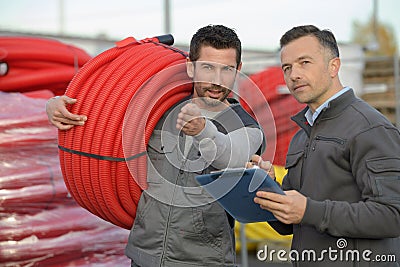 man carrying rolled hose Stock Photo